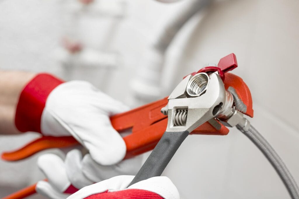 Plumber holding pipe wrenches for an emergency repair in Wildwood