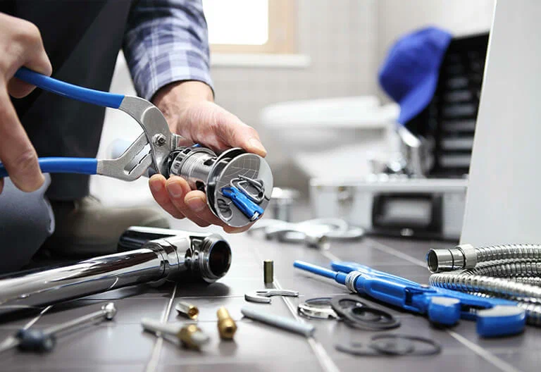 Technician repairing a plumbing fixture with professional tools in Wildwood