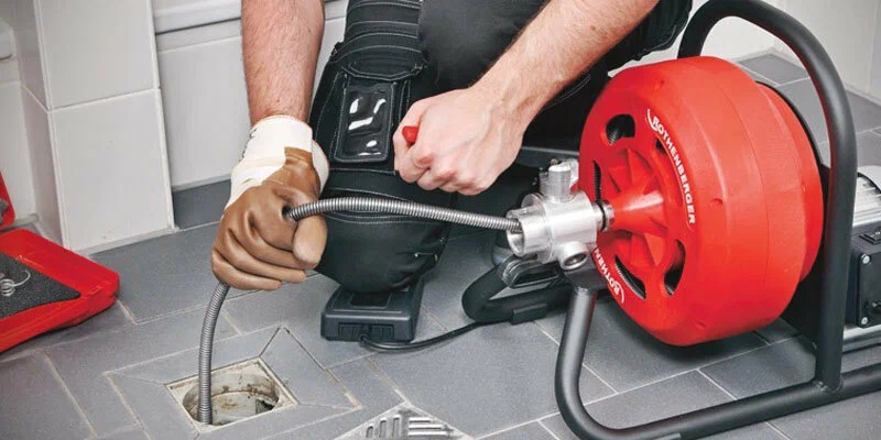 Plumber using a drain-cleaning machine in Wildwood