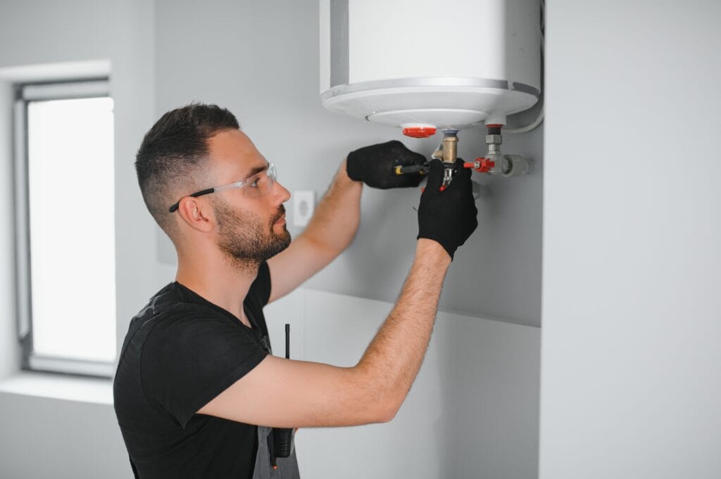 Technician performing water heater maintenance in Wildwood