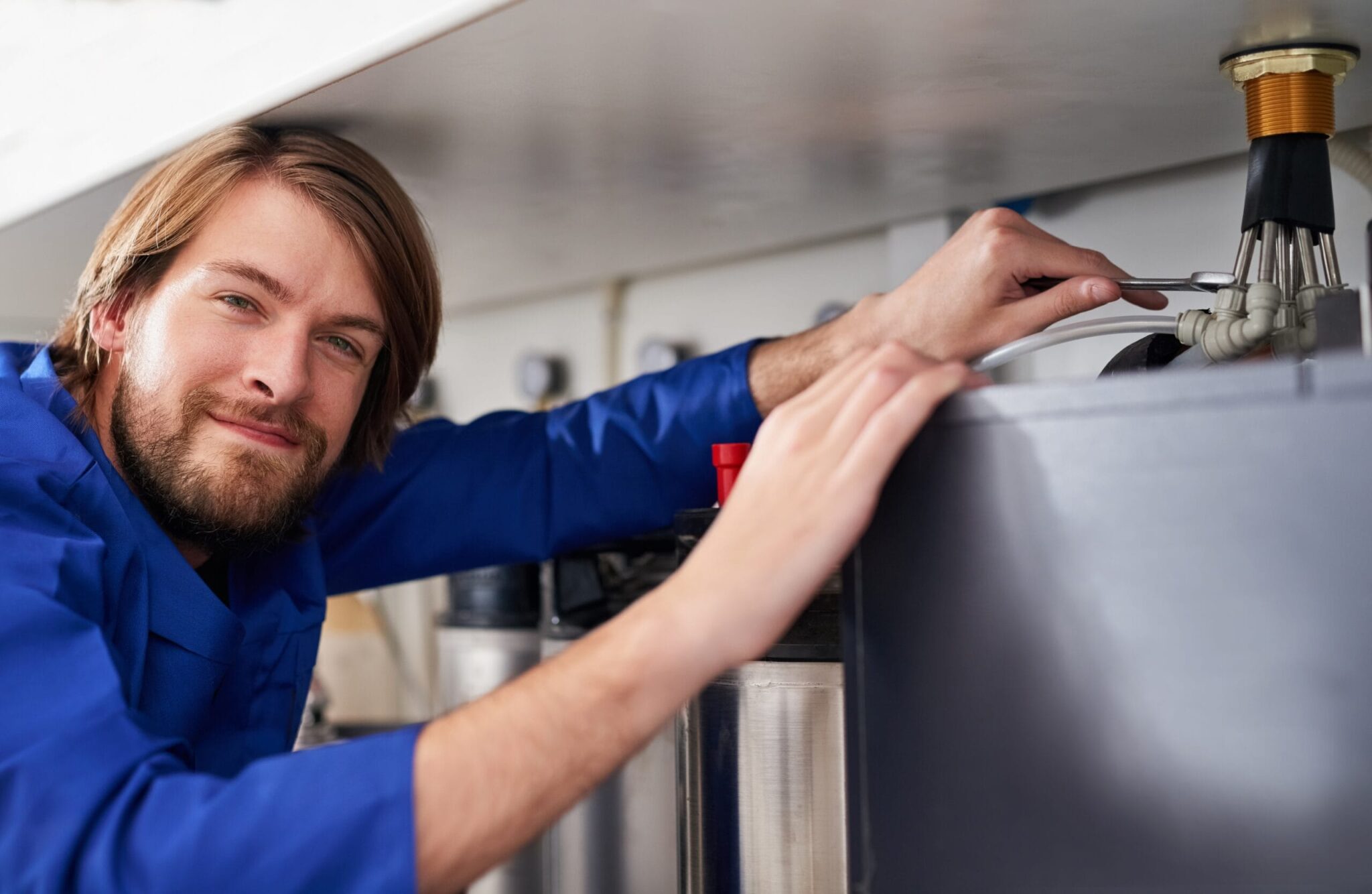 Technician servicing a residential water heater tank in Wildwood